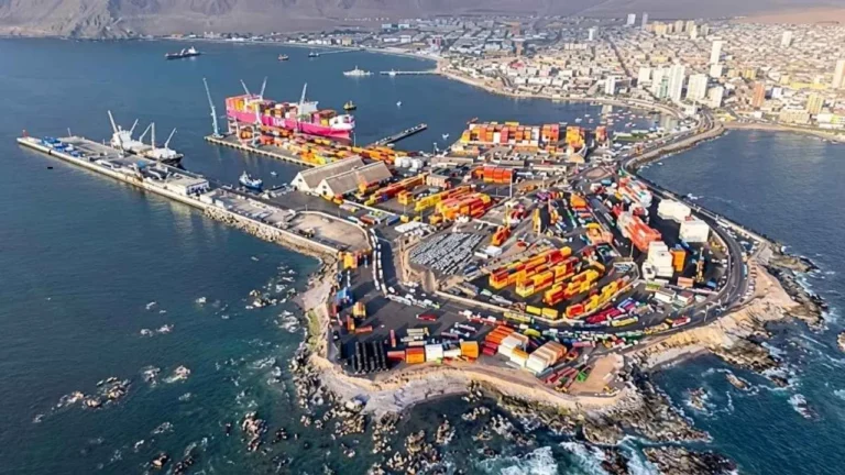 Operação portuária de carga e descarga no Porto de Iquique, no Chile, destacando contêineres e logística de transporte para a Bolívia.