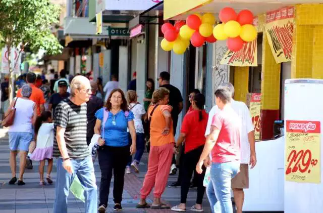 Pessoas transitando e comprando em lojas abertas no Carnaval em Campo Grande, MS.