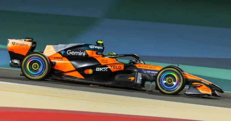 Carro de Fórmula 1 acelerando em uma curva no Grande Prêmio da Austrália, com iluminação dramática ao pôr do sol.