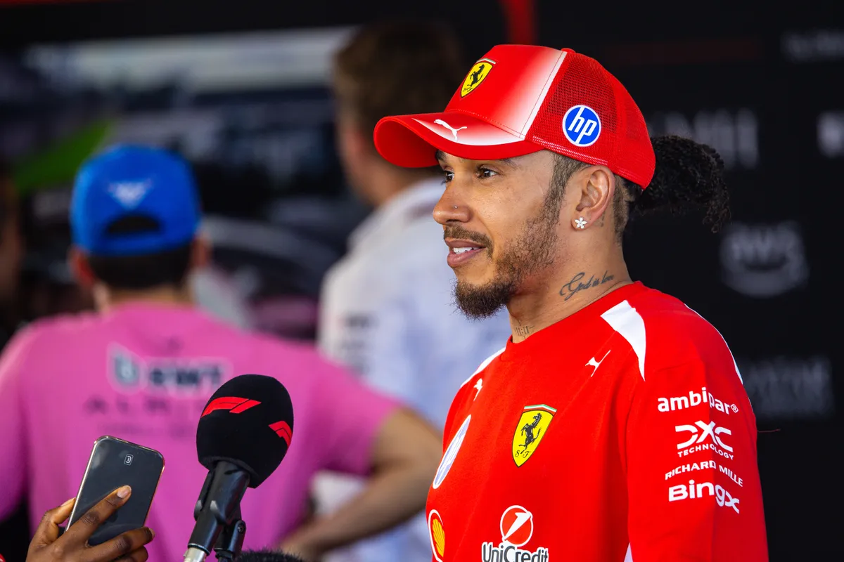 Lewis Hamilton em um carro da Ferrari durante o GP da Austrália, olhando para frente com expressão pensativa.