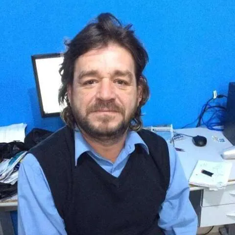 Jornalista Celso Bejarano em ambiente profissional, com expressão séria e reflexiva.