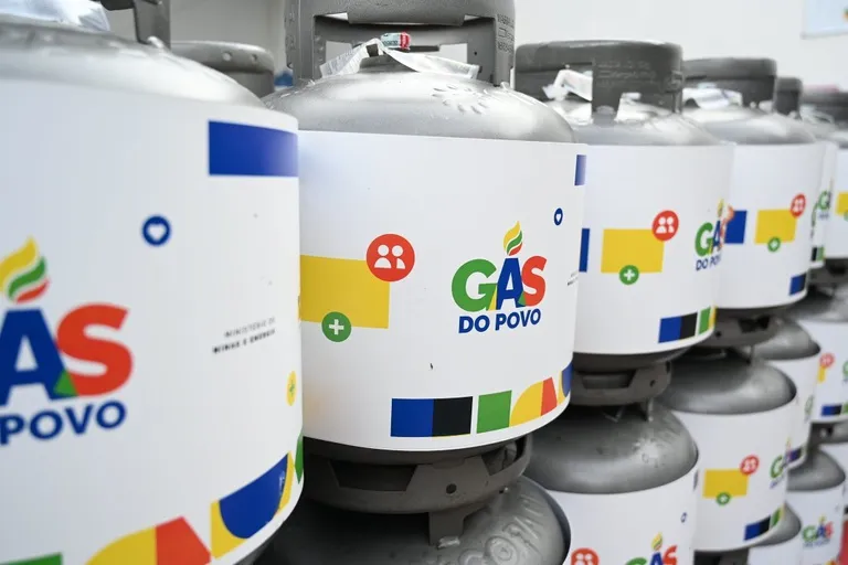 Mulher e criança recebendo botijão de gás do programa Gás do Povo em Mato Grosso do Sul, simbolizando assistência e combate à pobreza energética.