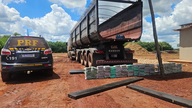 Agentes da PRF inspecionando caminhão e encontrando pacotes de cocaína em compartimentos ocultos na BR-262 em Terenos, MS.