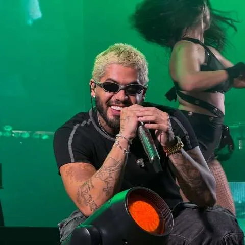 Zé Felipe sorrindo no palco, prometendo show gratuito em Ribas do Rio Pardo após problemas técnicos.