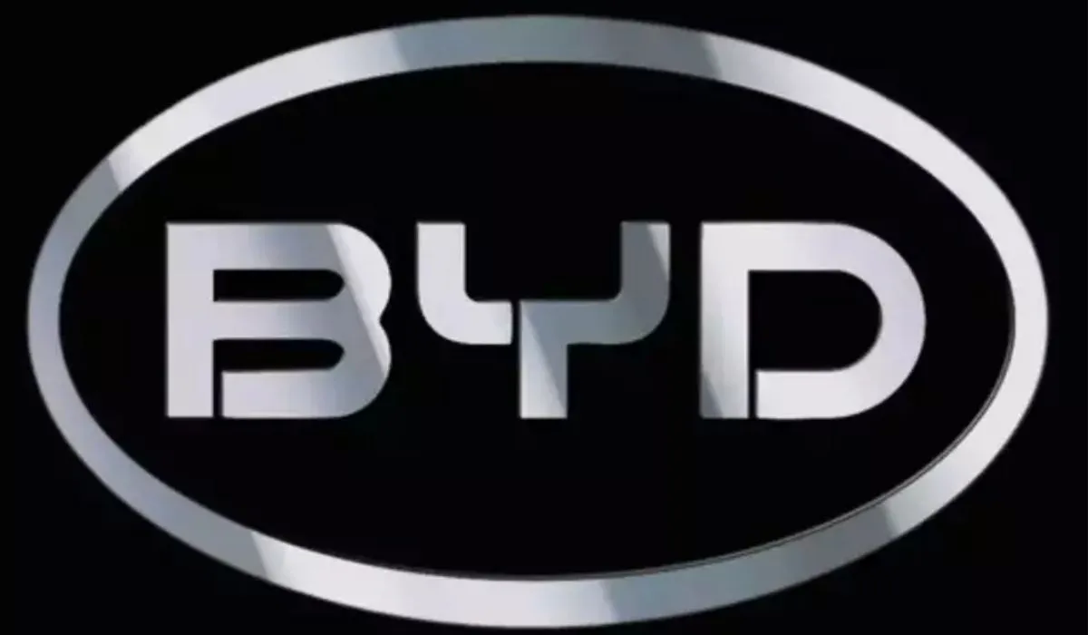 Carro de Fórmula 1 futurista com logo da BYD em pista de corrida ao pôr do sol