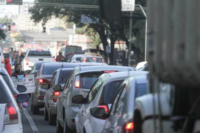 Motorista verificando o licenciamento veicular no aplicativo do Detran-MS com calendário ao fundo