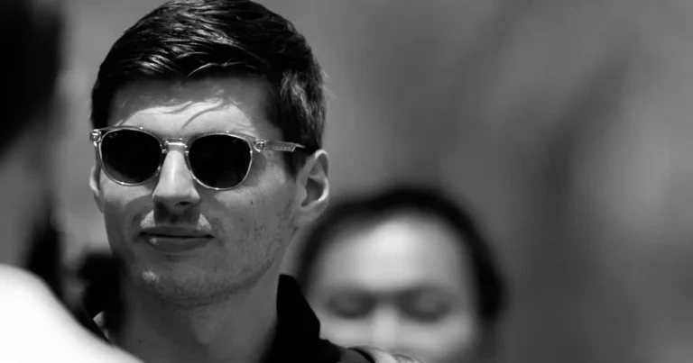 Max Verstappen no paddock com equipe ao fundo mostrando preocupação