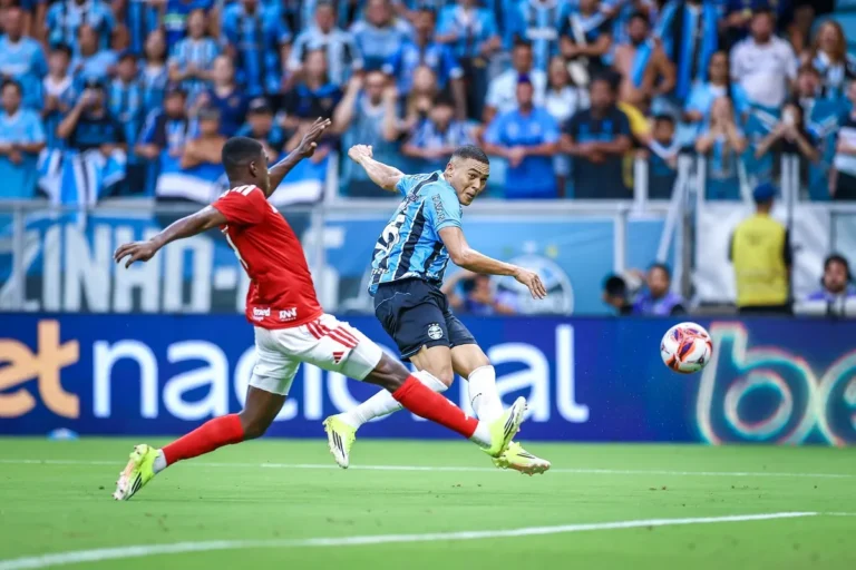 Jogadores de Internacional e Grêmio disputam bola em campo durante um clássico pelo Brasileirão.