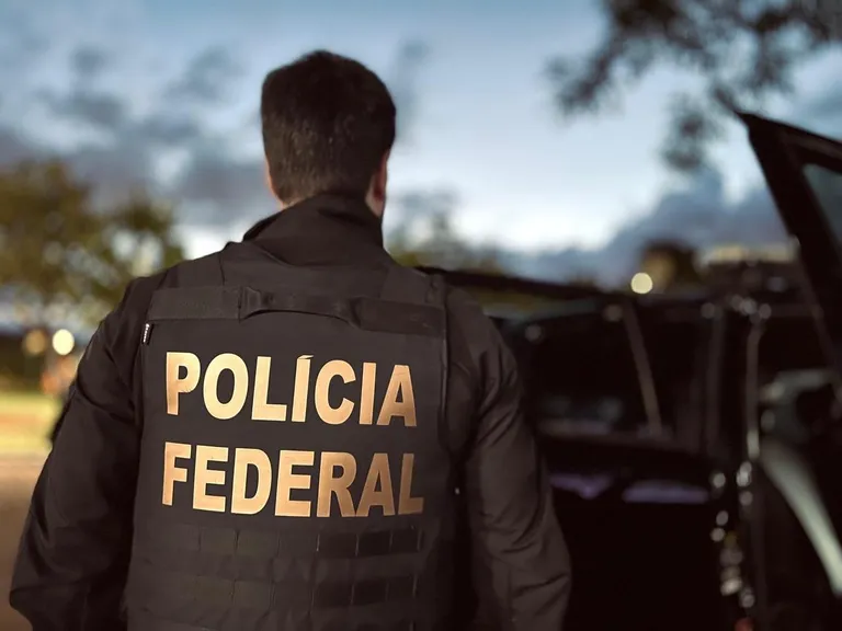 Distintivo da Polícia Federal sobre documentos de investigação de fraude em concurso público.