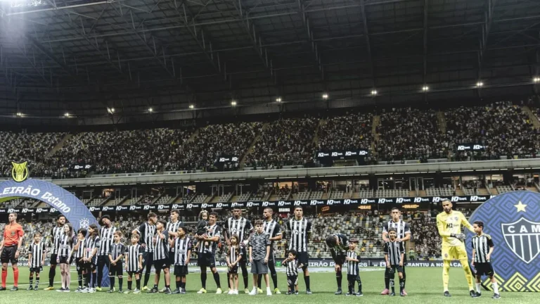 Jogadores do Atlético-MG comemoram gol diante da torcida com placar mostrando 3 a 1