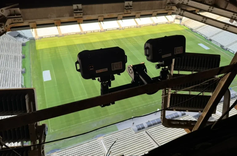 Técnicos instalando câmeras e equipamentos do impedimento semiautomático em estádio