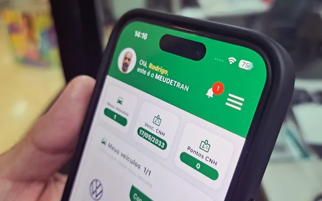 Fachada do Detran-MS com veículos e smartphone exibindo o Portal Meu Detran