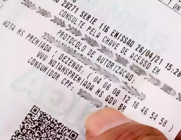 Bolas de loteria com os números sorteados e uma nota fiscal com CPF destacada representando o sorteio Nota MS Premiada.