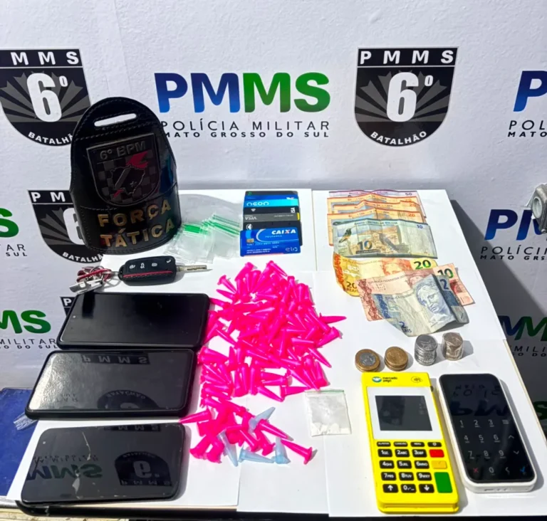 Policiais da Força Tática inspecionam veículo à noite; pinos de cocaína e material apreendido sobre o banco.
