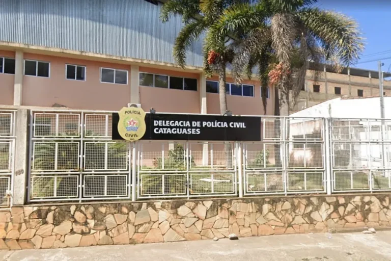 Fachada de casa com isolamento policial e fita zebrada à noite, representação simbólica do crime em Cataguases