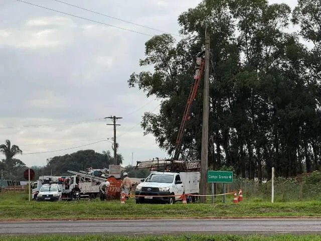 Técnicos removendo fios e transformador na Agrovila Campão enquanto moradores e policiais observam