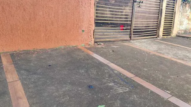 Calçada à noite com fitas de isolamento e manchas de sangue no Jardim Água Boa, Dourados