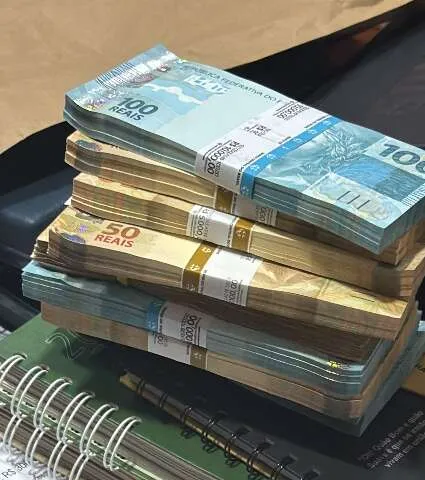 Agentes do Gaeco apreendendo talões de cheques e documentos durante operação