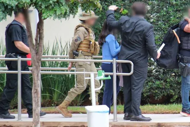 Investigadores recolhendo caixas com livros e documentos durante operação policial