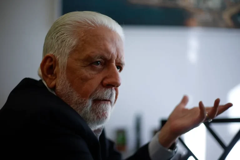 Senador Jaques Wagner em ambiente institucional durante entrevista, expressão séria