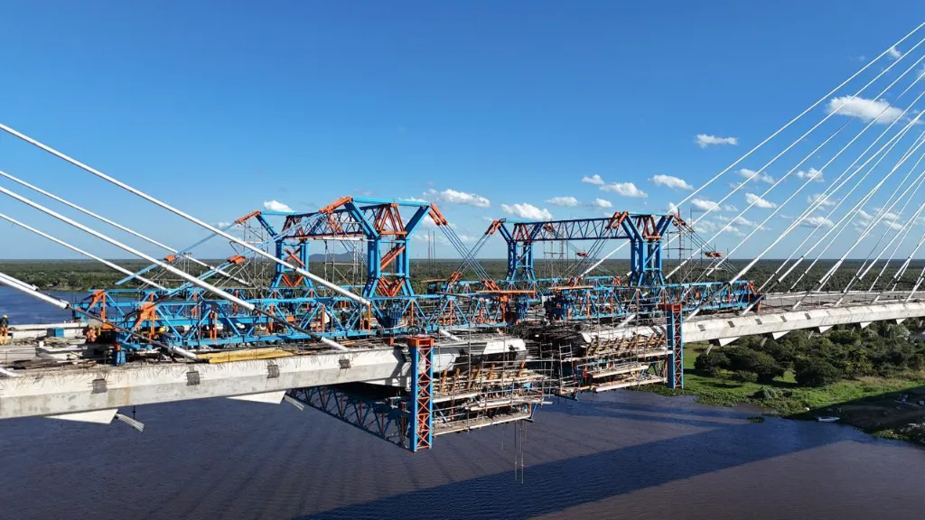 Vista aérea da Ponte Bioceânica em construção com as extremidades quase se unindo sobre o rio Paraguai