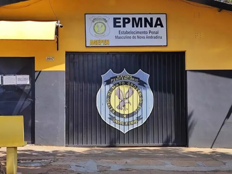 Fachada do presídio de Nova Andradina à noite com viaturas e fita de isolamento