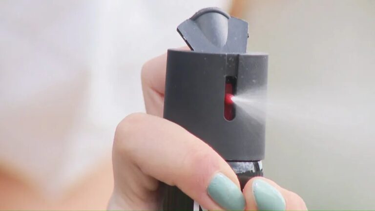 Mulher segurando spray de pimenta e documentos em frente a prateleira de loja