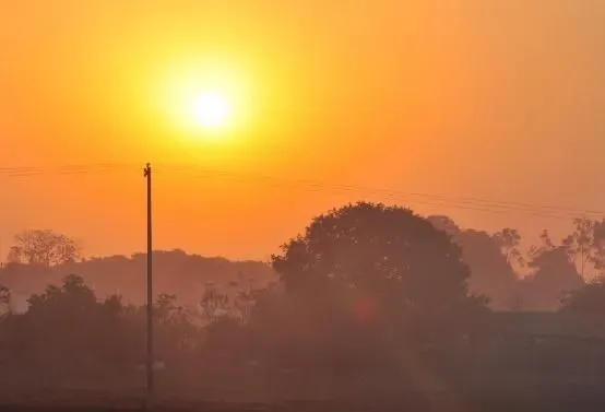 Paisagem seca com solo rachado, vegetação ressecada e sol forte, representando baixa umidade do ar em Mato Grosso do Sul