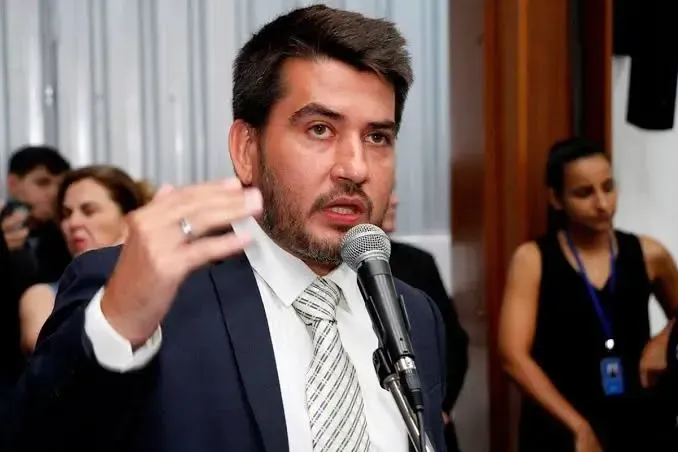 Martelo de juiz sobre documentos com plenário do STF desfocado e tela de rede social com mensagem de ódio pixelada