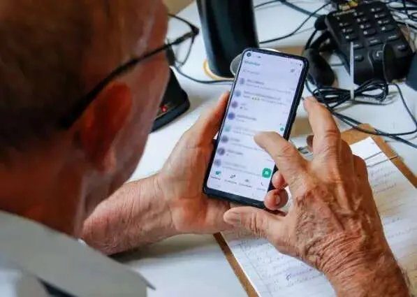 Idoso assinando formulário em cartório com escrevente observando atento