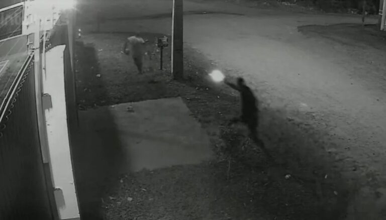 Rua no Jardim Noroeste com motocicleta vermelha e suspeitos durante a noite