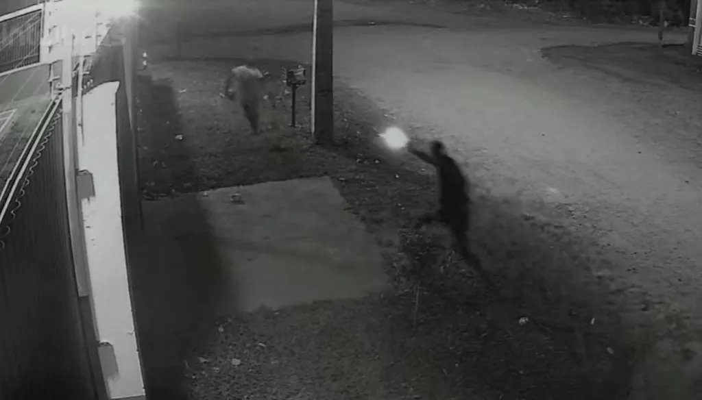 Rua no Jardim Noroeste com motocicleta vermelha e suspeitos durante a noite