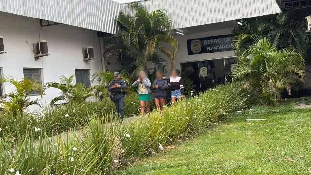 Viatura da polícia em frente à delegacia com cartaz de criança desaparecida