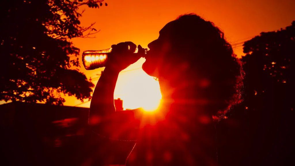 Termômetro marcando 41°C em paisagem seca do Mato Grosso do Sul