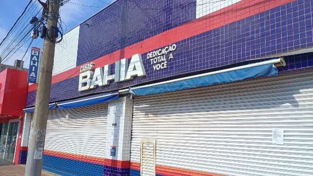 Loja da Casas Bahia fechada em shopping, com portas de vidro e placa de encerramento.