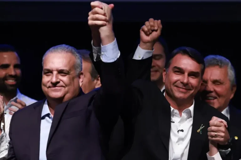 Mesa de reunião política com documentos e bandeira do Brasil, representando a formação de chapa eleitoral