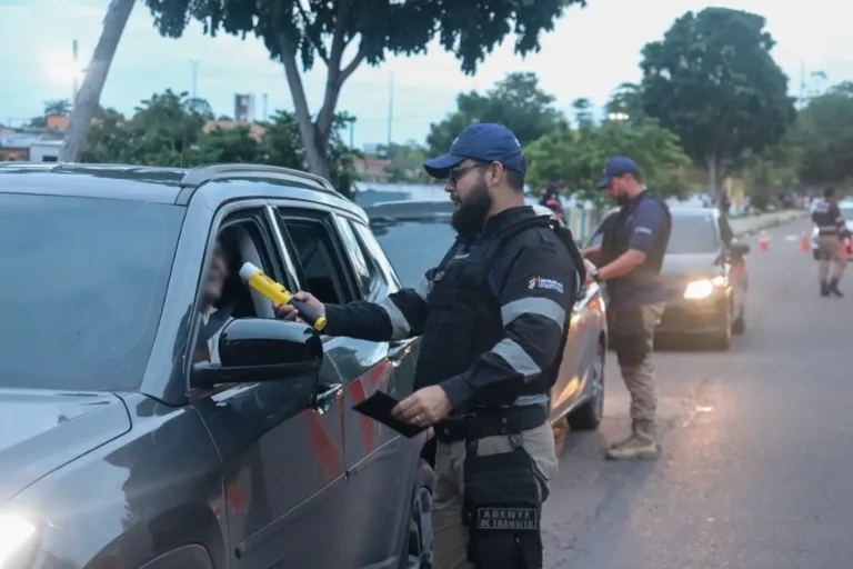 Agente de trânsito realiza pré-teste de alcoolemia em motorista durante blitz noturna
