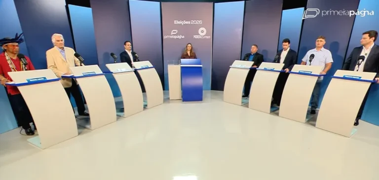 Palco de debate político vazio com cadeiras e câmeras de TV
