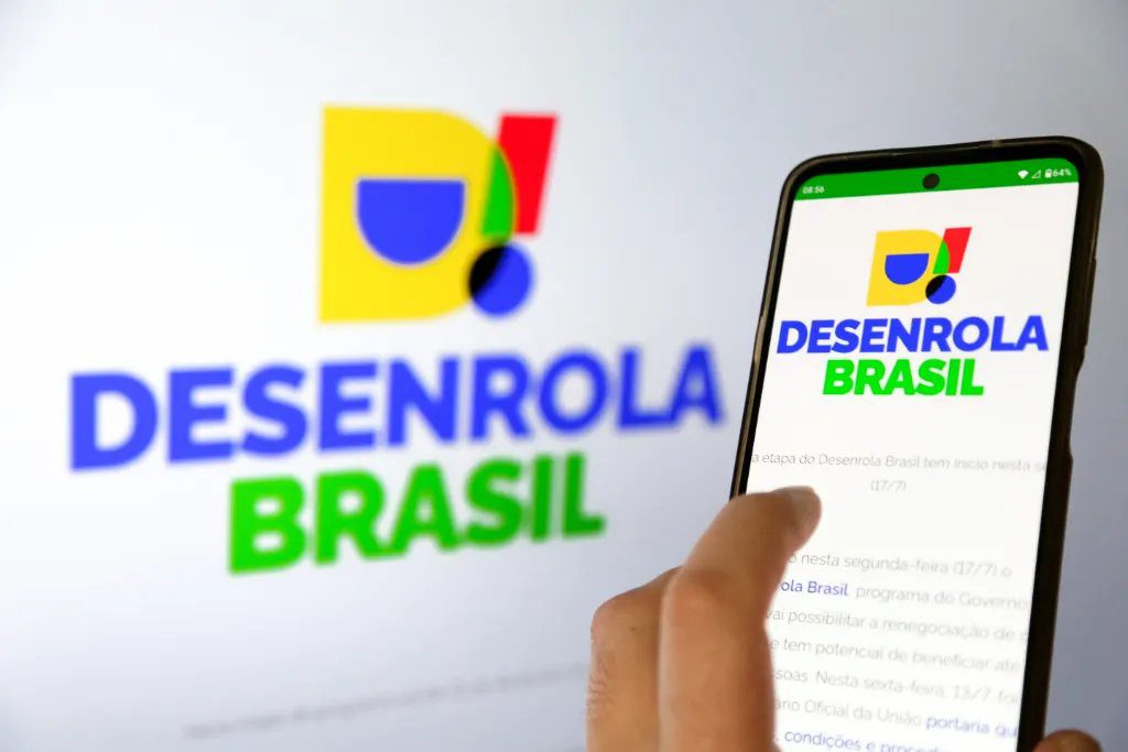 Smartphone com símbolo de proibido sobre aposta esportiva, representando a exclusão do Desenrola 2.0