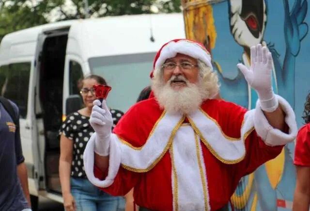 Papai Noel sentado em poltrona decorada em shopping center