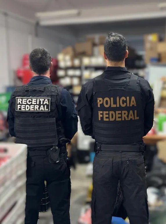Agentes da PF e Receita Federal durante operação de busca em galpão de autopeças