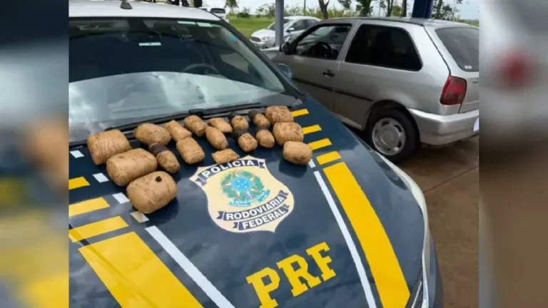 Policial rodoviário federal inspeciona carro prata durante fiscalização na BR-158
