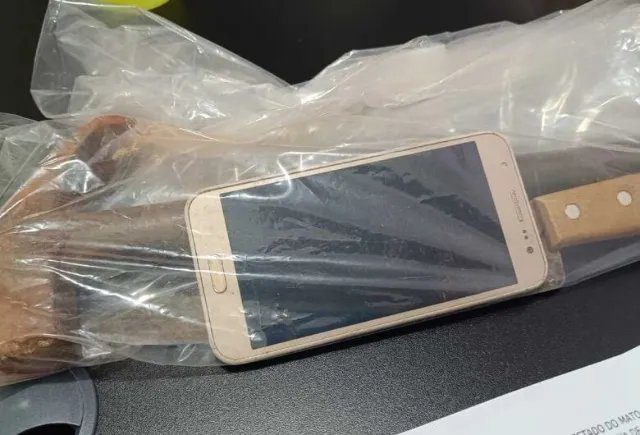 Mulher ferida sendo amparada por policial enquanto homem é preso ao fundo