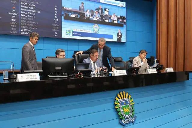 Prédio da Assembleia Legislativa de Mato Grosso do Sul com brasão e pessoas