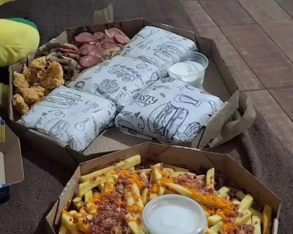 Fachada de lanchonete em Campo Grande com presença policial à noite