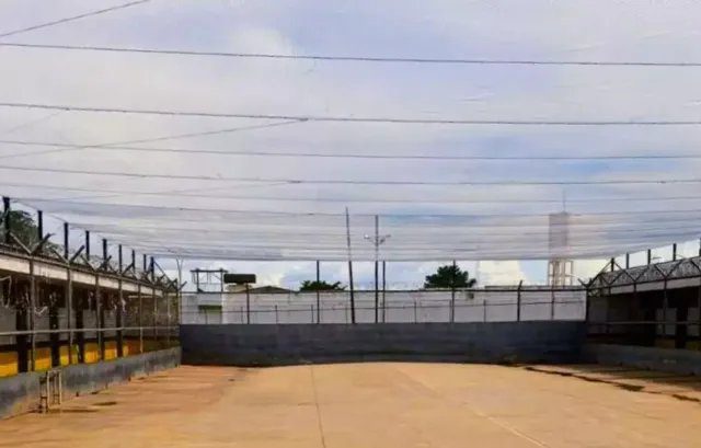 Cela prisional vazia com clima sombrio, destacando ambiente insalubre.