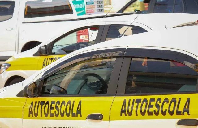 Candidato faz prova da CNH com carro particular ao lado de examinador.